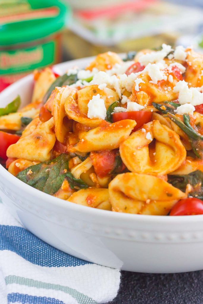 This Spinach and Feta Tortellini is fresh, flavorful, and ready in less than 30 minutes. Cheese tortellini is tossed in a zesty marinara sauce and sprinkled with fresh spinach and crumbled feta cheese. Easy to make and perfect for busy weeknights, this warm and comforting pasta will fill you up and keep you coming back for more!