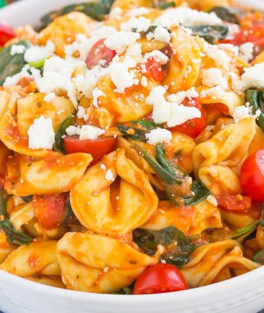This Spinach and Feta Tortellini is fresh, flavorful, and ready in less than 30 minutes. Cheese tortellini is tossed in a zesty marinara sauce and sprinkled with fresh spinach and crumbled feta cheese. Easy to make and perfect for busy weeknights, this warm and comforting pasta will fill you up and keep you coming back for more!