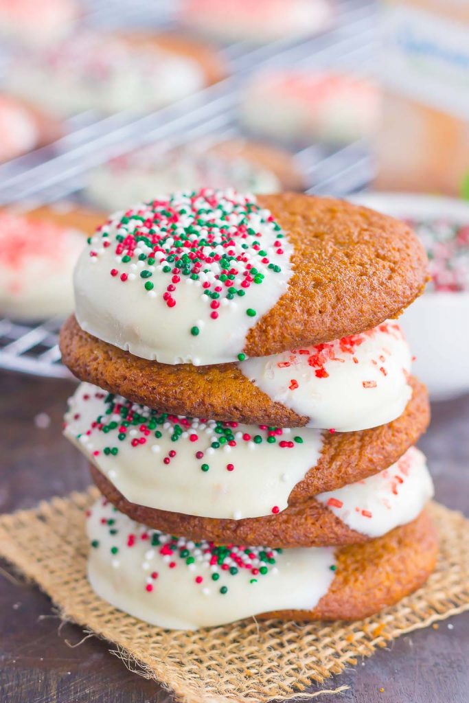 A stack of four soft gingersnap cookies dipped in white chocolate.