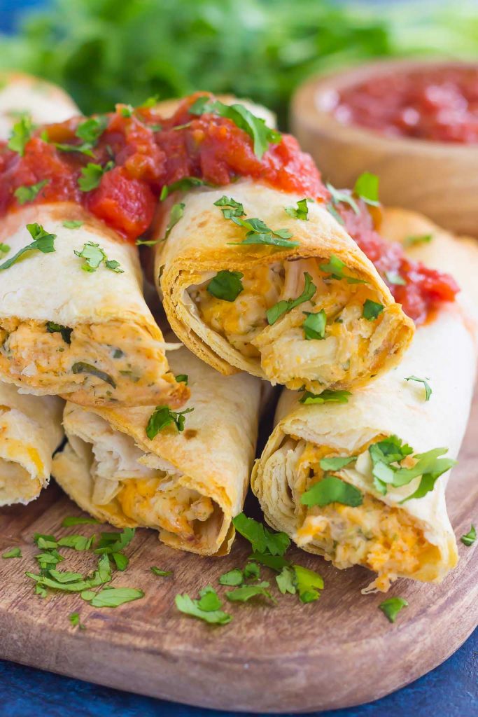 These Baked Chicken Ranch Taquitos are loaded with shredded chicken, cheddar cheese, cilantro, and a savory ranch cream cheese mixture. Fast, easy, and ready in less than 30 minutes, this simple dish is packed with flavor and perfect for the whole family! #chicken #taquitos #chickentaquitos #bakedchicken #chickendinner #chickenrecipe #mexicanrecipe #dinner