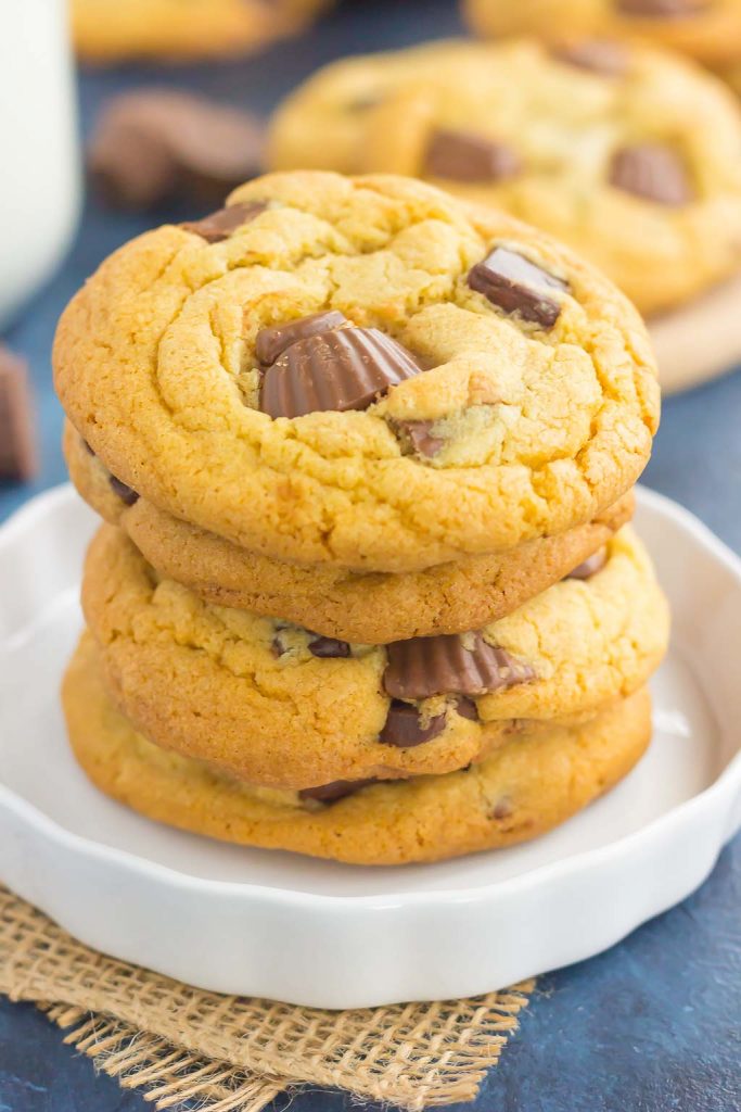 A stack of chocolate chip peanut butter cup cookies on a white plate. 