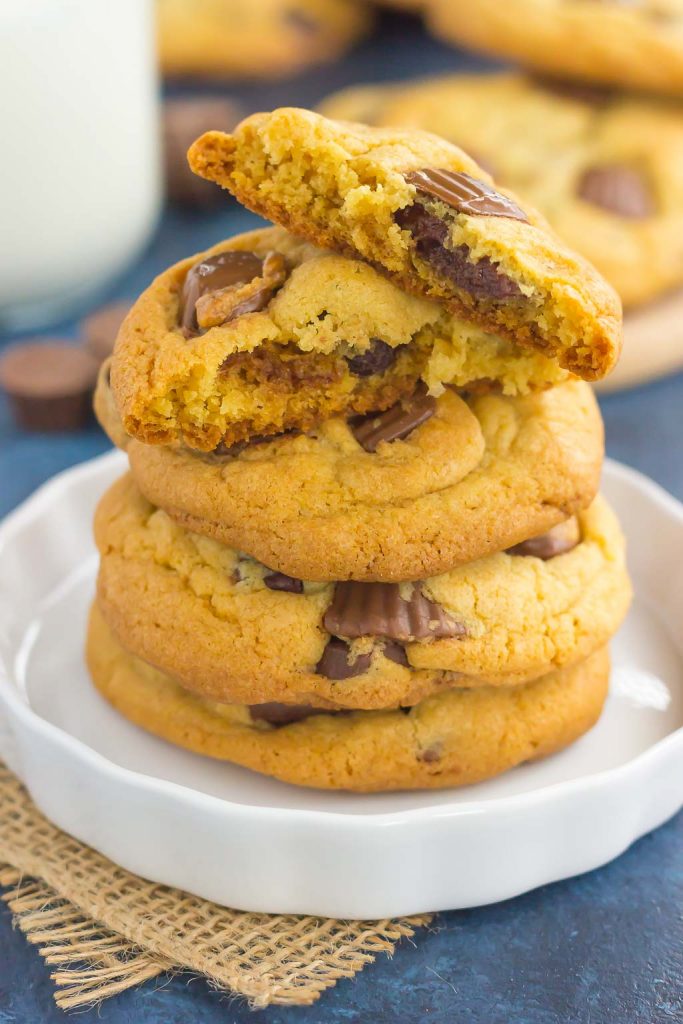 A stack of Reese's peanut butter cup cookies on a white plate. The top cookie has been halved.