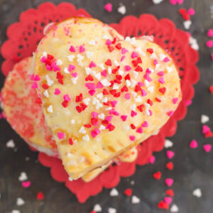 These Mini Strawberry Heart Pies are the perfect dessert for spoiling your sweetie on Valentine's Day or for entertaining those party guests. A pre-made pie crust is cut into the shape of hearts and then filled with sweet strawberry jam. It's an impressive treat that looks time-consuming but is so easy to make!