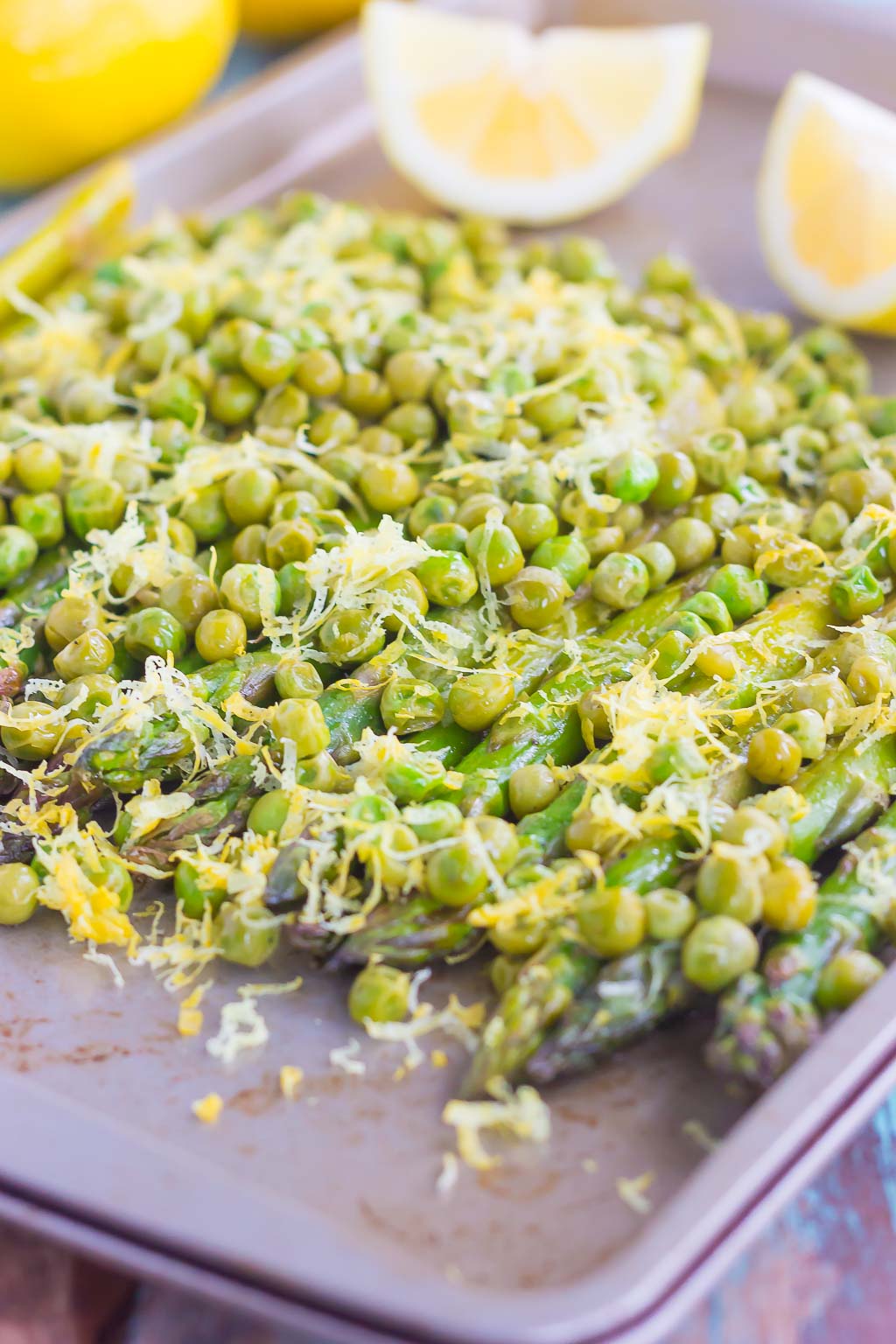 Roasted Asparagus and Peas with Lemon is an easy side dish that's bursting with flavor. Fresh asparagus and peas are drizzled with olive oil, roasted until tender, and then topped with a lemon zest mixture. Simple, fresh, and delicious, this will become your new favorite way to eat your veggies!