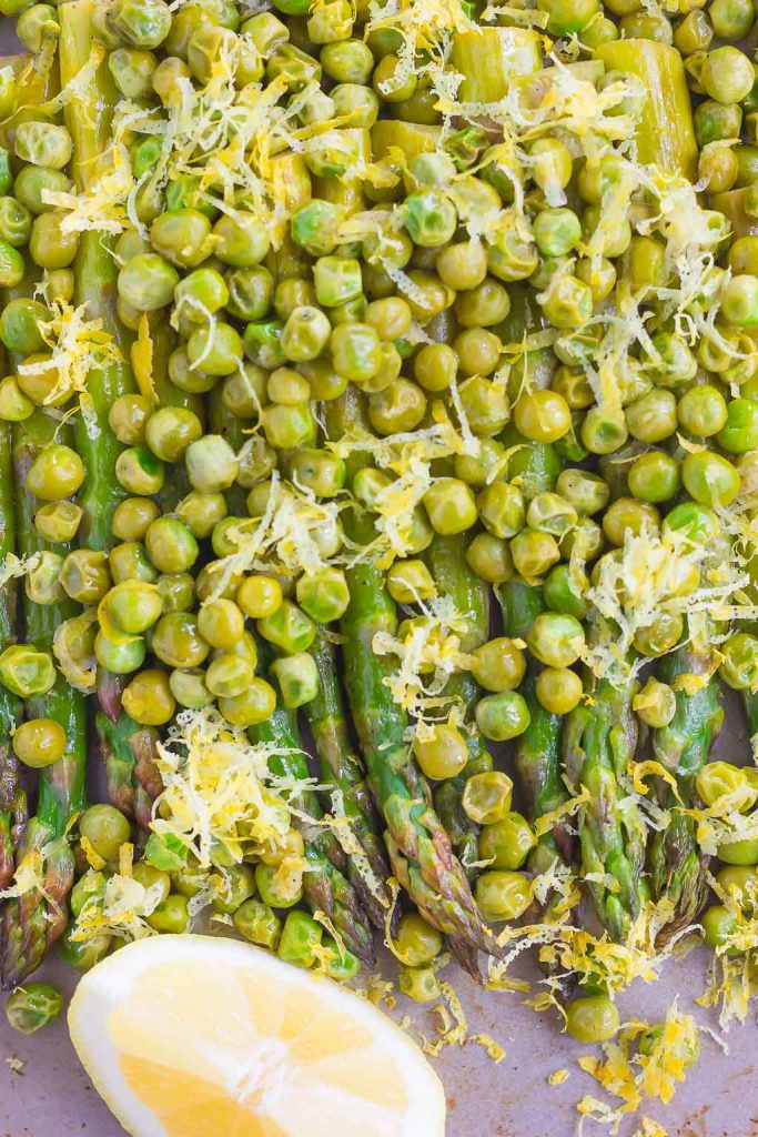 Overhead view of lemon asparagus and peas on a baking sheet. 