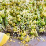 Roasted Asparagus and Peas with Lemon is an easy side dish that's bursting with flavor. Fresh asparagus and peas are drizzled with olive oil, roasted until tender, and then topped with a lemon zest mixture. Simple, fresh, and delicious, this will become your new favorite way to eat your veggies!