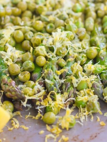 Roasted Asparagus and Peas with Lemon is an easy side dish that's bursting with flavor. Fresh asparagus and peas are drizzled with olive oil, roasted until tender, and then topped with a lemon zest mixture. Simple, fresh, and delicious, this will become your new favorite way to eat your veggies!