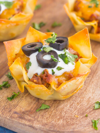 These Cheesy Taco Cups are the perfect game day snack. Your favorite taco ingredients are layered in wonton wrappers and baked in mini form. Easy to make and even better to eat, you'll enjoy these handheld cups that are packed with so much flavor!