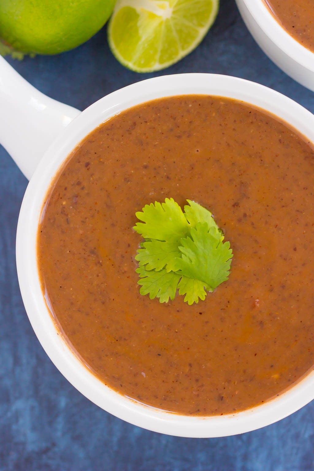 Overhead view of creamy black bean soup in a white soup bowl.