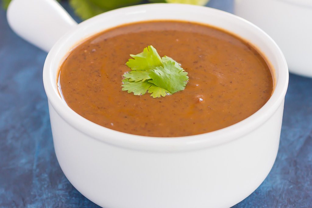 Creamy black bean soup in a white soup bowl. 