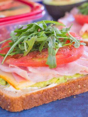 This Ham and Avocado Open-Faced Sandwich is simple, fresh, and perfect for a light lunch or dinner. Honey ham and tangy cheese is piled high on a slice of thick bread, then garnished with mayonnaise, avocado, and fresh tomato. With just six ingredients and hardly any prep time involved, you can have this easy sandwich ready in no time!