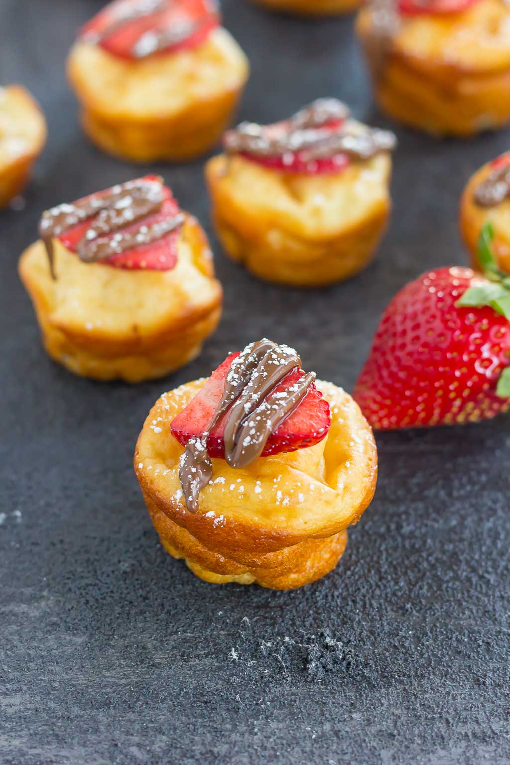 mini nutella pancake bites garnished with strawberry slices and nutella