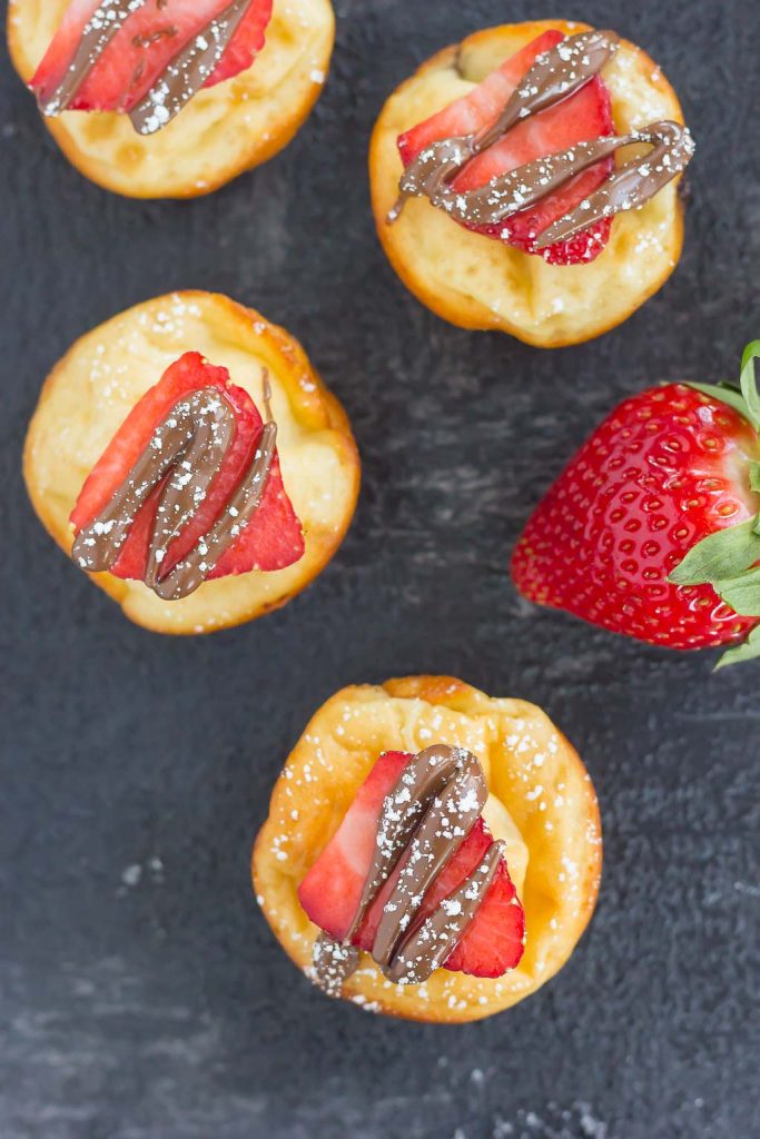 overhead view of nutella pancake bites garnished with strawberry slices and nutella 