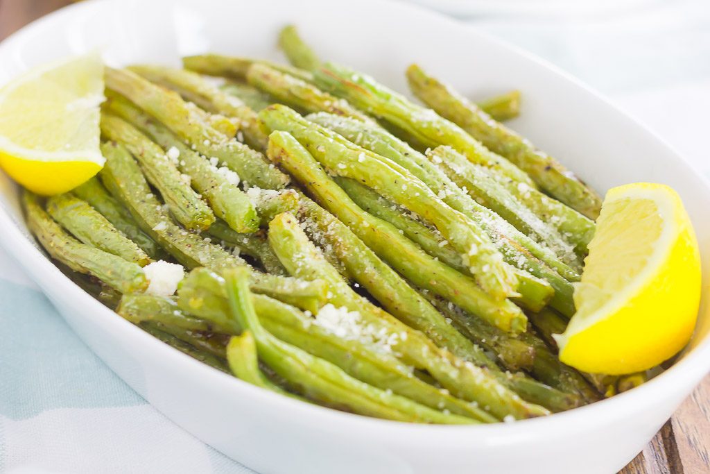 Roasted green beans with lemon and garlic in a white dish. 