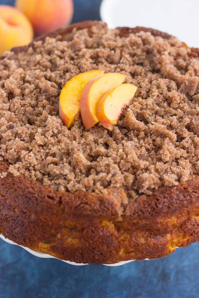 peach cake with crumb topping garnished with peach slices
