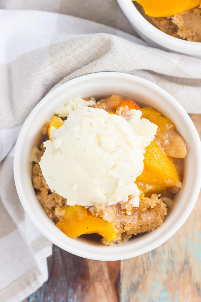 This Crock Pot Peach Cobbler is loaded with juicy peaches, a sprinkling of cozy spices, and layered with a crispy, cakey topping.