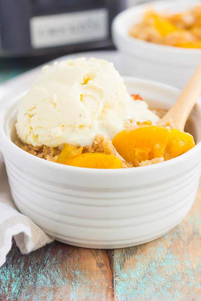 This Crock Pot Peach Cobbler is loaded with juicy peaches, a sprinkling of cozy spices, and layered with a crispy, cakey topping.