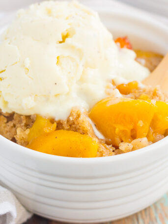 This Slow Cooker Peach Cobbler is loaded with juicy peaches, a sprinkling of cozy spices, and layered with a crispy, cakey topping. Just throw everything into the slow cooker, set it, and forget it. In just a few hours, you'll have a warm and flavorful dessert ready to be devoured!