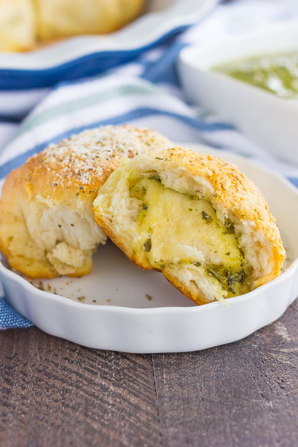 These Stuffed Cheesy Pesto Rolls are an easy dish to make for those hungry dinner guests. Soft and buttery rolls are filled with pesto sauce and mozzarella cheese, and then baked until golden. Crispy on the outsize and oozing with flavor on the inside, this simple roll is sure to wow even the pickiest of eaters!