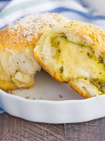 These Stuffed Cheesy Pesto Rolls are an easy dish to make for those hungry dinner guests. Soft and buttery rolls are filled with pesto sauce and mozzarella cheese, and then baked until golden. Crispy on the outsize and oozing with flavor on the inside, this simple roll is sure to wow even the pickiest of eaters!