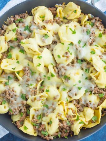 This Cheesy Beef Tortellini Skillet is a simple, one pan meal that's bursting with flavor. Loaded with ground beef, spices, tortellini, and cheese, this easy meal is family-friendly and so delicious!