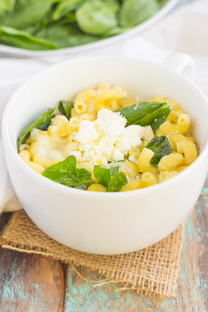 All it takes is just one mug and 5 minutes to make this Microwave Mug Spinach and Feta Macaroni and Cheese. Tender pasta, mozzarella and feta cheeses and a sprinkling of spinach create an easy, cheesy, and oh-so delicious single serving recipe for the best macaroni and cheese! #macncheese #macaroniandcheese #macandcheese #spinach #feta #fetamacandcheese #pasta #microwave #dinner