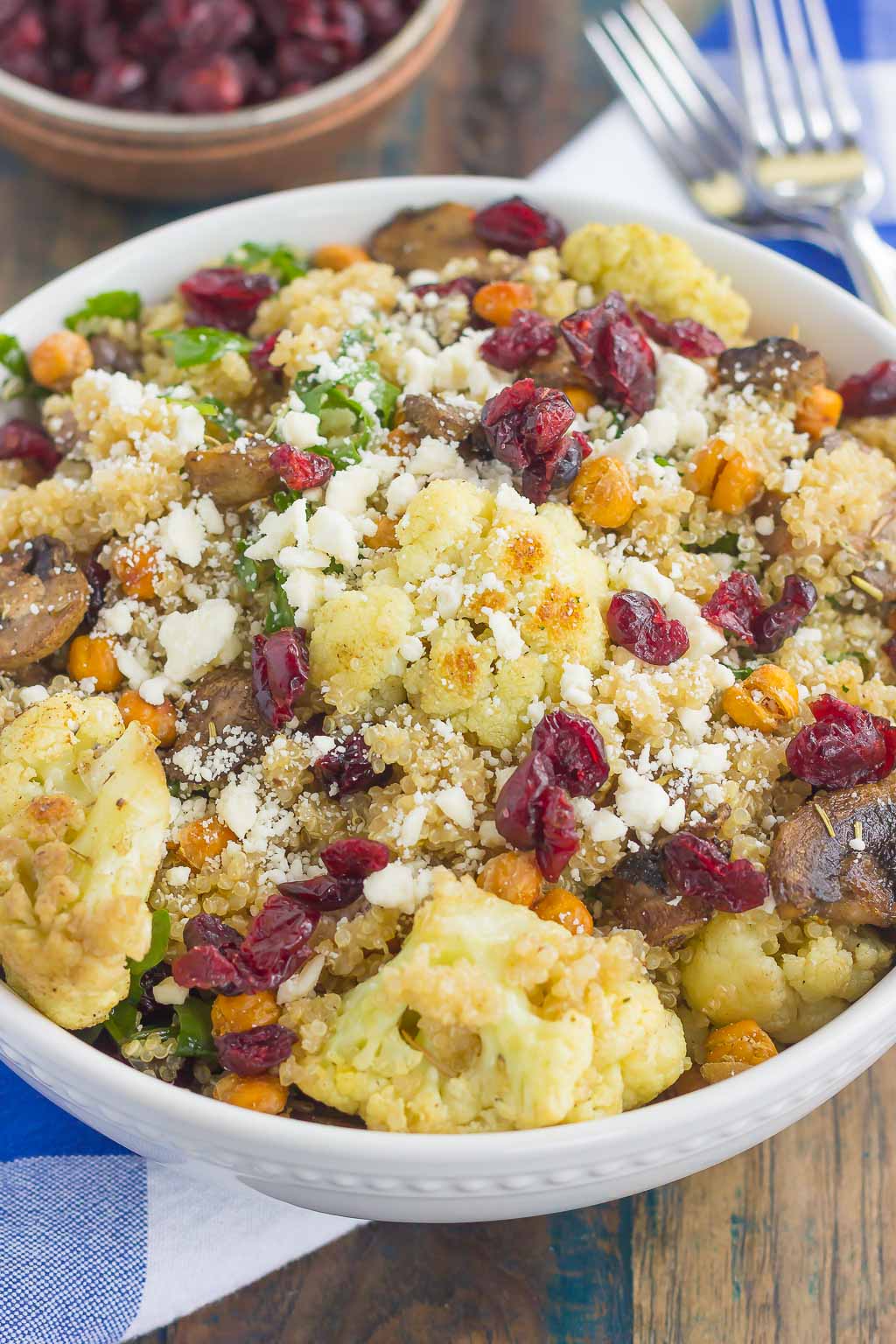 This Roasted Cauliflower, Mushroom and Chickpea Quinoa Bowl is a quick and easy meatless meal that is sure to please everyone. Hearty quinoa is tossed with roasted cauliflower, mushrooms, chickpeas, and arugula, all tossed in a savory white balsamic dressing. This healthier meal is ready in just 30 minutes and packed with delicious superfoods!