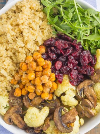 This Roasted Cauliflower, Mushroom and Chickpea Quinoa Bowl is a quick and easy meatless meal that is sure to please everyone. Hearty quinoa is tossed with roasted cauliflower, mushrooms, chickpeas, and arugula, all tossed in a savory white balsamic dressing. This healthier meal is ready in just 30 minutes and packed with delicious superfoods!
