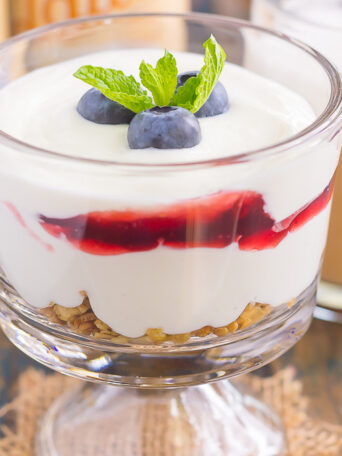 This Blueberry Cheesecake Breakfast Parfait is the best way to start the day. Vanilla Greek yogurt is infused with cream cheese and then layered with blueberries for the ultimate parfait. Light, creamy, and packed with flavor, this easy breakfast or snack is perfect for everyone!