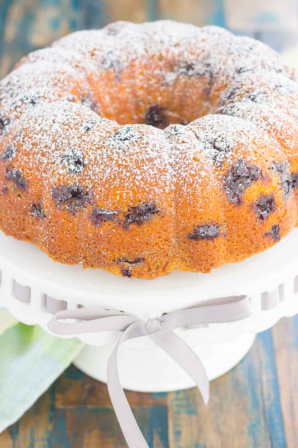 A lemon blueberry yogurt cake on a cake stand. 