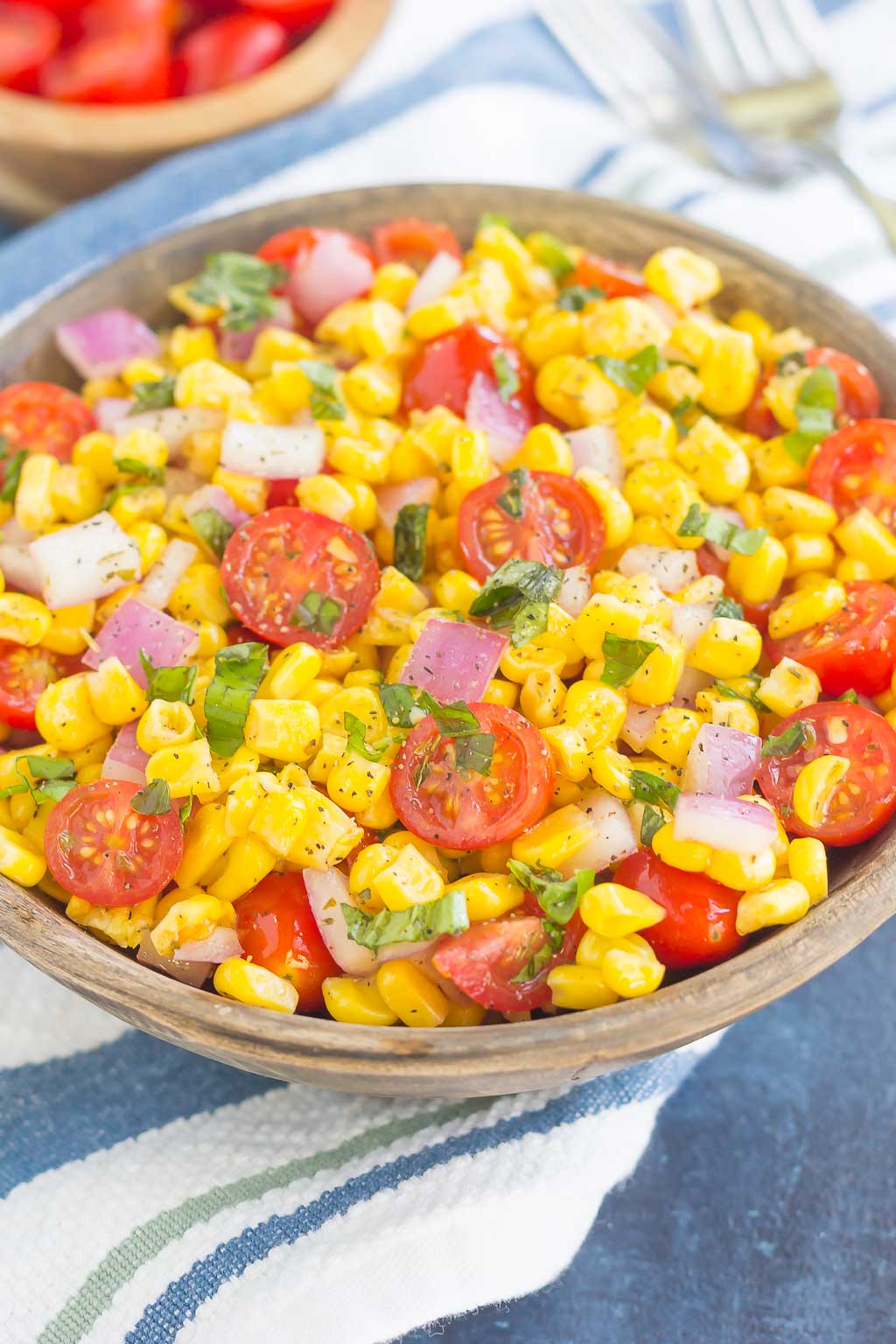 With fresh corn cut straight from the cob, cherry tomatoes, spices, and a light dressing, this Corn and Tomato Salad is perfect for a summer lunch or dinner! #corn #cornsalad #tomato #tomatosalad #corntomatosalad #salad #saladrecipe #summersalad