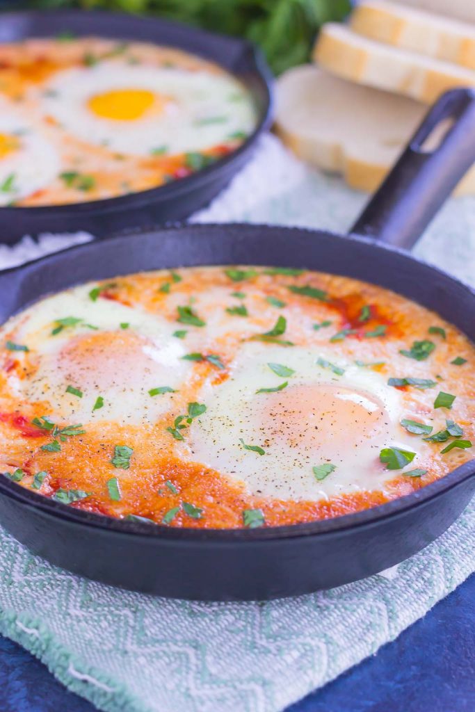 These Marinara Baked Eggs make an easy and hearty meal for busy mornings. Perfect alongside toast, garlic bread, or on its own, this dish is sure to be a favorite all year long! #eggs #bakedeggs #marinaraeggs #marinarabakedeggs #breakfast 