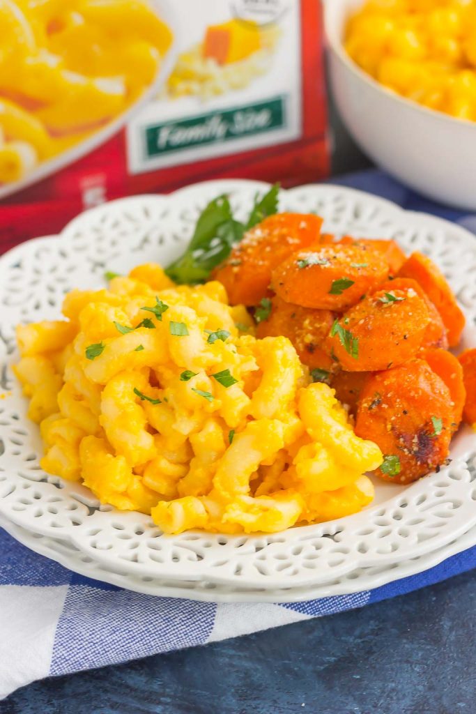 A white plate with mac and cheese and honey roasted carrots. 