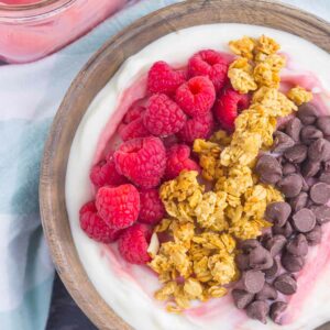This Raspberry Grapefruit Yogurt Bowl is a delicious way to start the day. It's packed with creamy vanilla Greek yogurt, a swirl of raspberry grapefruit curd, and topped with a combination of sweet ingredients. Fresh, flavorful, and light, this is the best way to switch up your breakfast or snack routine!
