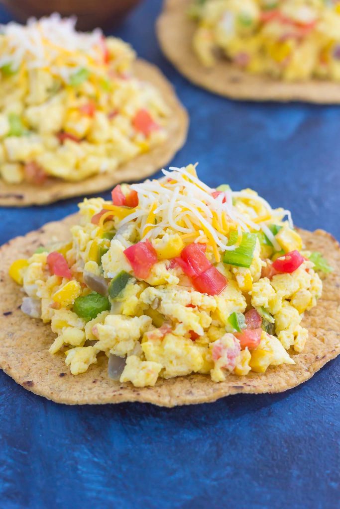 This Southwest Scramble Tostada is simple, 20 minute breakfast that is sure to get your day off to a great start. Fluffy scrambled eggs are tossed with green peppers, onion, corn, and tomatoes, and then added to a crunchy tostada shell and sprinkled with cheese. Easy, fresh, and full of flavor, this dish is sure to become a regular in your meal rotation!