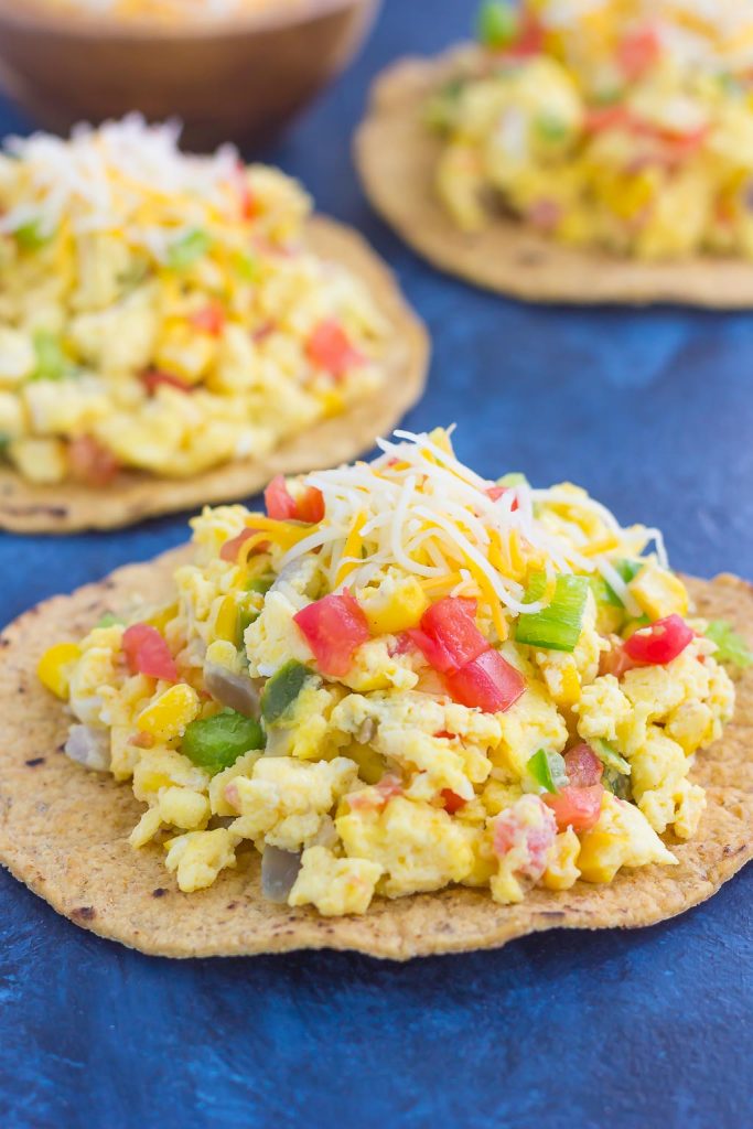 This Southwest Scramble Tostada is simple, 20 minute breakfast that is sure to get your day off to a great start. Fluffy scrambled eggs are tossed with green peppers, onion, corn, and tomatoes, and then added to a crunchy tostada shell and sprinkled with cheese. Easy, fresh, and full of flavor, this dish is sure to become a regular in your meal rotation!