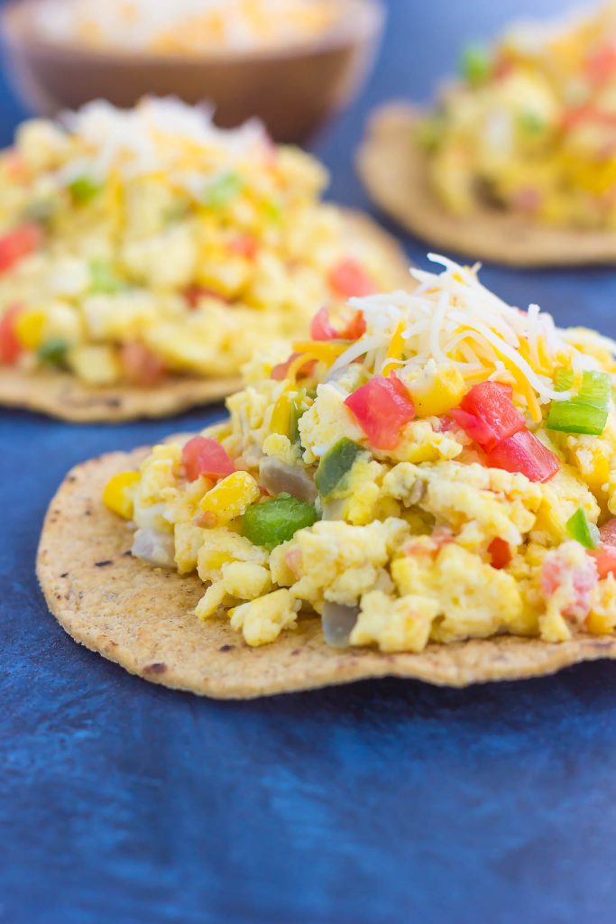 This Southwest Scramble Tostada is simple, 20 minute breakfast that is sure to get your day off to a great start. Fluffy scrambled eggs are tossed with green peppers, onion, corn, and tomatoes, and then added to a crunchy tostada shell and sprinkled with cheese. Easy, fresh, and full of flavor, this dish is sure to become a regular in your meal rotation!