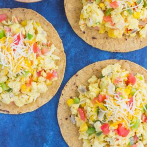 This Southwest Scramble Tostada is simple, 20 minute breakfast that is sure to get your day off to a great start. Fluffy scrambled eggs are tossed with green peppers, onion, corn, and tomatoes, and then added to a crunchy tostada shell and sprinkled with cheese. Easy, fresh, and full of flavor, this dish is sure to become a regular in your meal rotation!