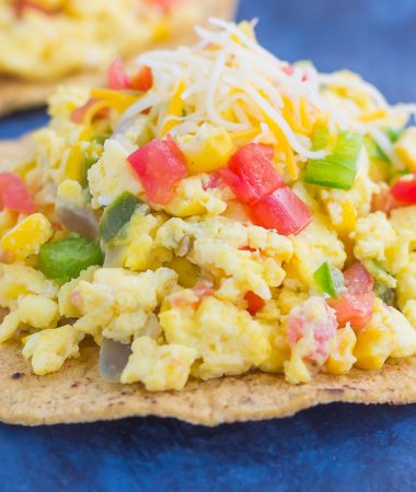 This Southwest Scramble Tostada is simple, 20 minute breakfast that is sure to get your day off to a great start. Fluffy scrambled eggs are tossed with green peppers, onion, corn, and tomatoes, and then added to a crunchy tostada shell and sprinkled with cheese. Easy, fresh, and full of flavor, this dish is sure to become a regular in your meal rotation!
