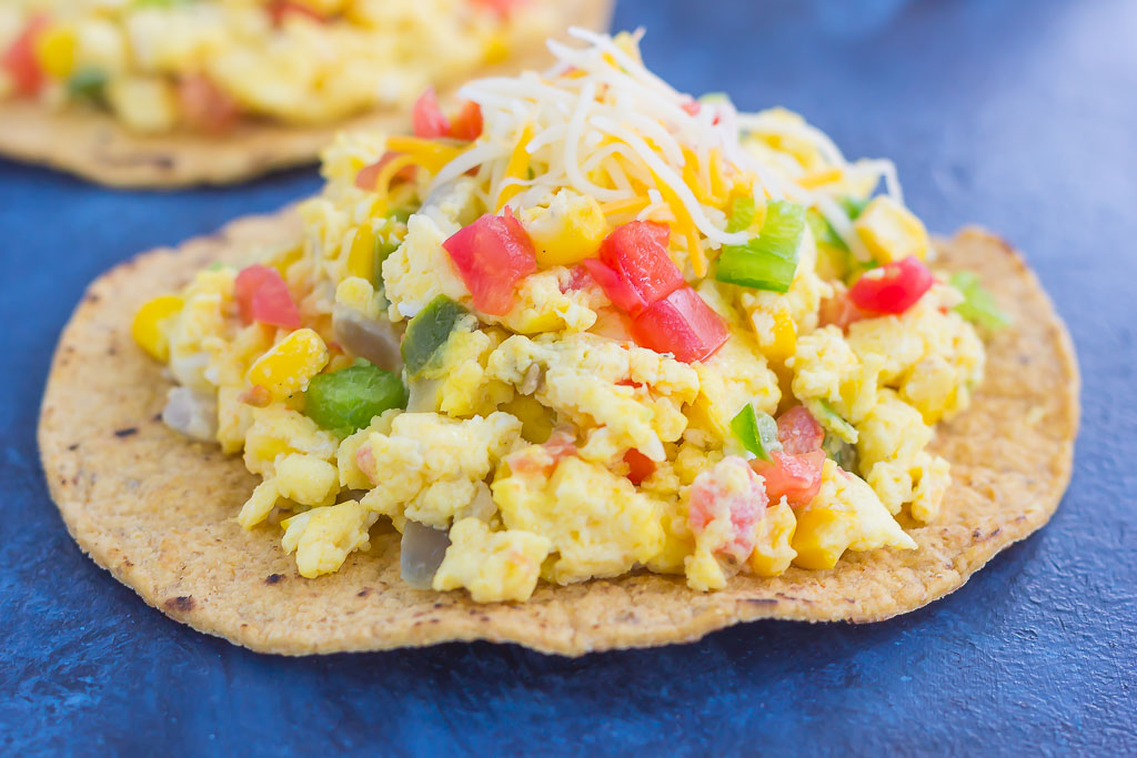 This Southwest Scramble Tostada is simple, 20 minute breakfast that is sure to get your day off to a great start. Fluffy scrambled eggs are tossed with green peppers, onion, corn, and tomatoes, and then added to a crunchy tostada shell and sprinkled with cheese. Easy, fresh, and full of flavor, this dish is sure to become a regular in your meal rotation!