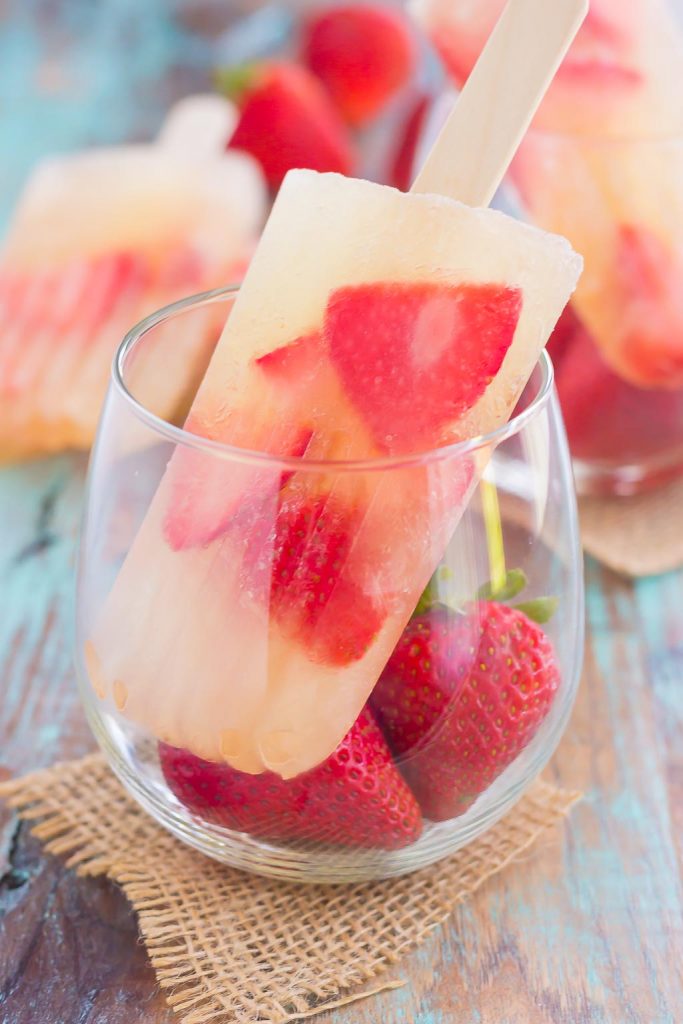These Strawberry Champagne Pops are the perfect treat to beat the summer heat. Filled with sweet champagne and fresh strawberries, these two ingredient pops are a delicious way to cool off all season long!