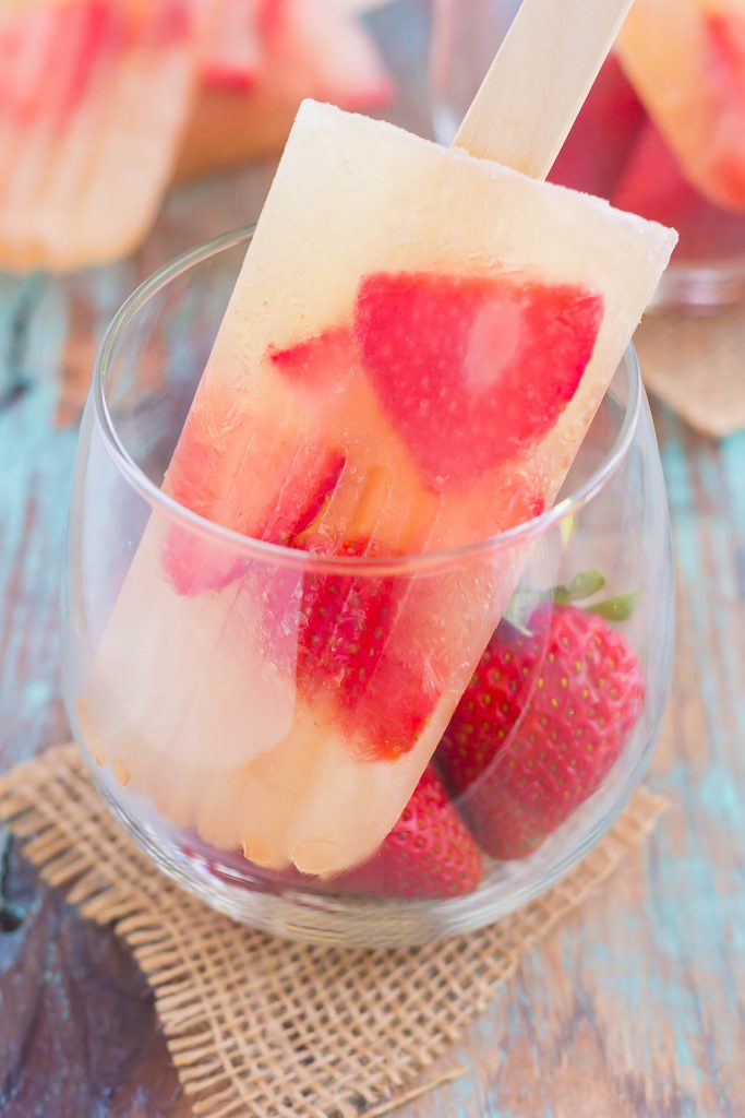 These Strawberry Champagne Pops are the perfect treat to beat the summer heat. Filled with sweet champagne and fresh strawberries, these two ingredient pops are a delicious way to cool off all season long!