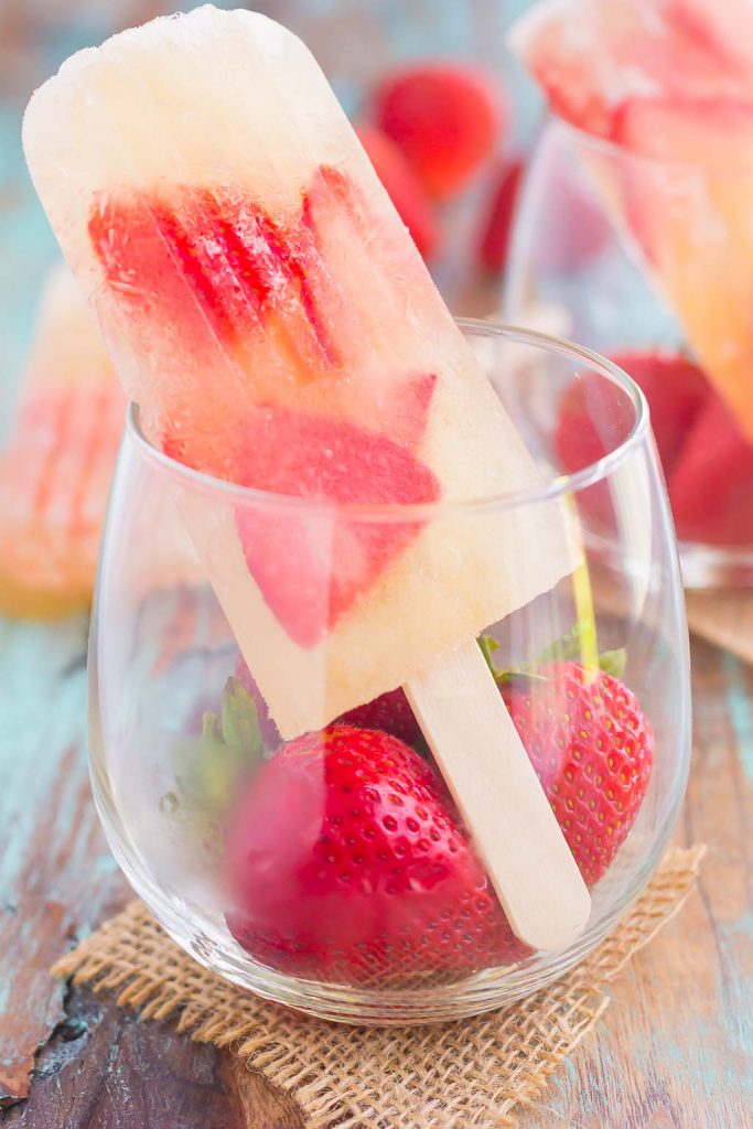 These Strawberry Champagne Pops are the perfect treat to beat the summer heat. Filled with sweet champagne and fresh strawberries, these two ingredient pops are a delicious way to cool off all season long!