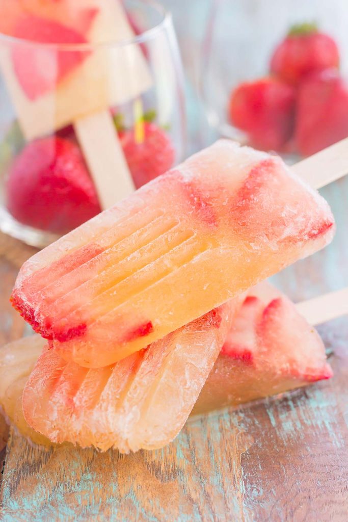 These Strawberry Champagne Pops are the perfect treat to beat the summer heat. Filled with sweet champagne and fresh strawberries, these two ingredient pops are a delicious way to cool off all season long!