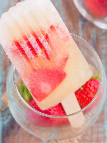These Strawberry Champagne Pops are the perfect treat to beat the summer heat. Filled with sweet champagne and fresh strawberries, these two ingredient pops are a delicious way to cool off all season long!
