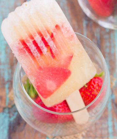 These Strawberry Champagne Pops are the perfect treat to beat the summer heat. Filled with sweet champagne and fresh strawberries, these two ingredient pops are a delicious way to cool off all season long!
