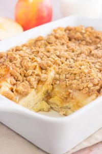 french toast casserole in a white dish with a piece cut out