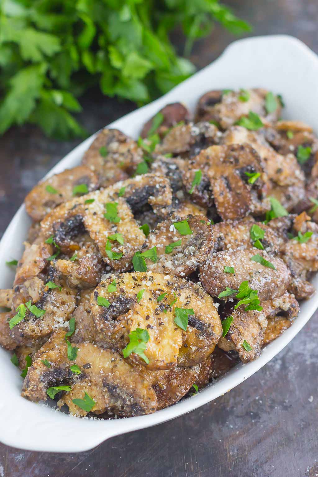 These Baked Parmesan Garlic Mushrooms are seasoned to perfection with garlic, basil, and Parmesan cheese. Easy to prepare and even better to eat, you will be making this side dish all the time!