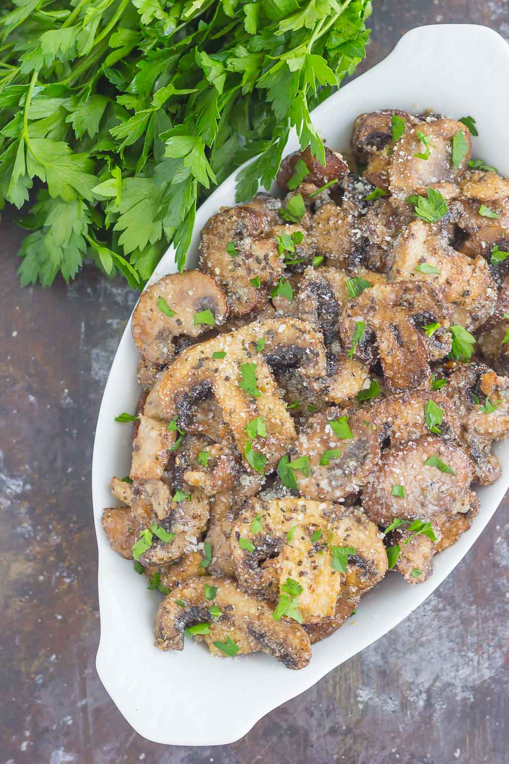 These Baked Parmesan Garlic Mushrooms are seasoned to perfection with garlic, basil, and Parmesan cheese. Easy to prepare and even better to eat, you will be making this side dish all the time!