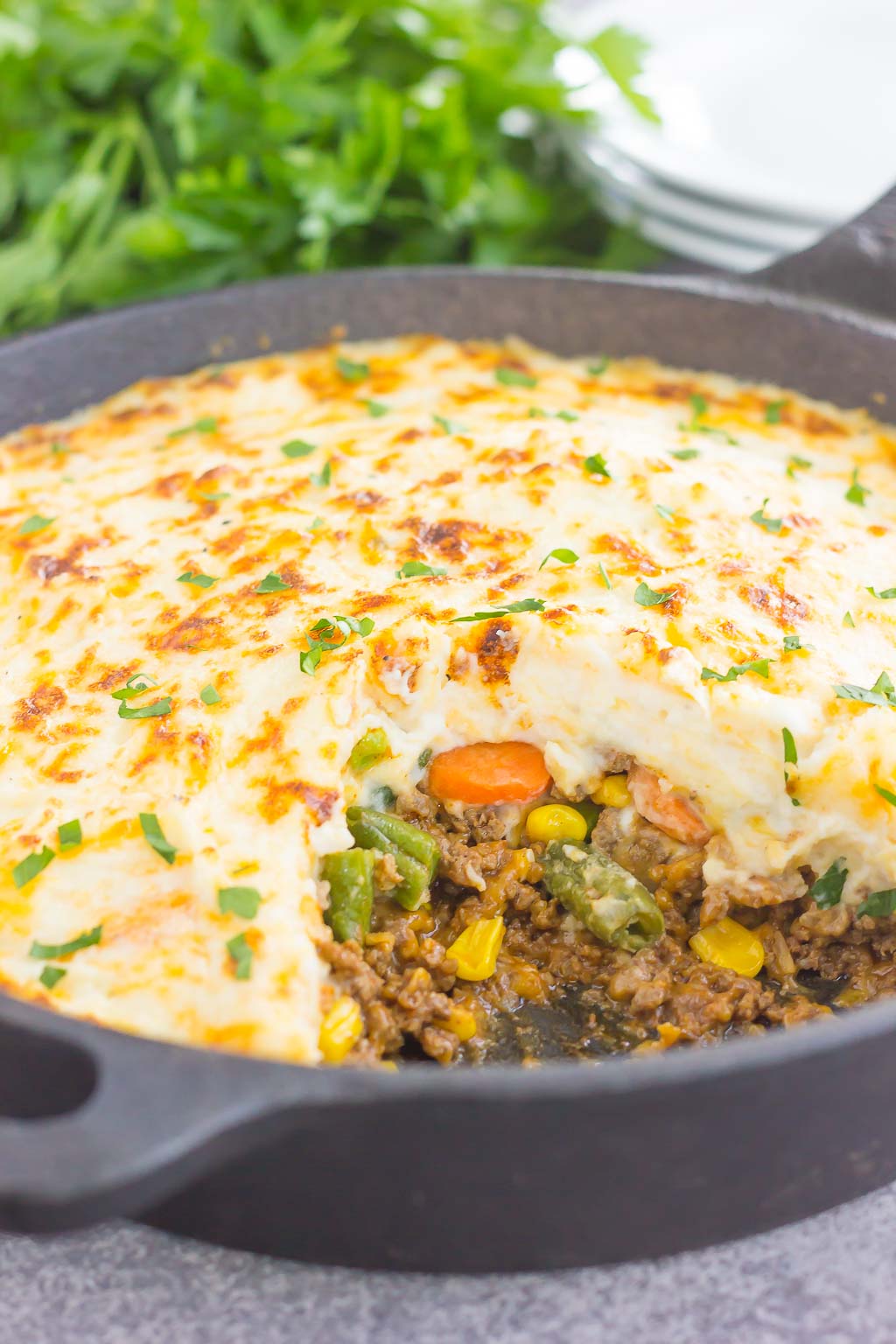 simple shepherd's pie in a cast iron skillet. a portion is missing. 